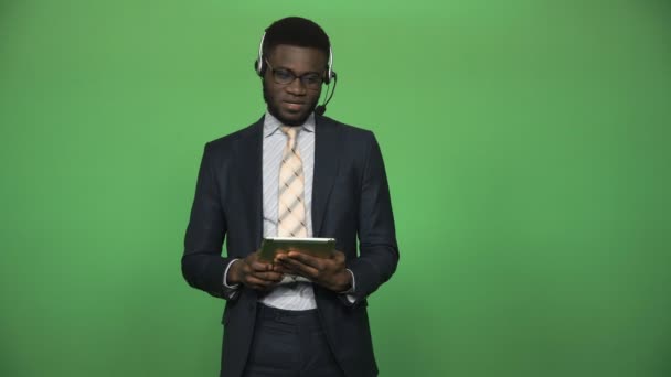 Afrikaanse mannelijke steun callcenter met Tablet PC- en headset — Stockvideo
