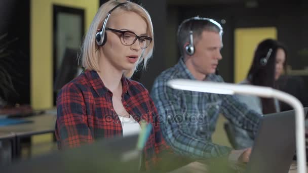 Mujer aplicando lápiz labial en call center — Vídeo de stock