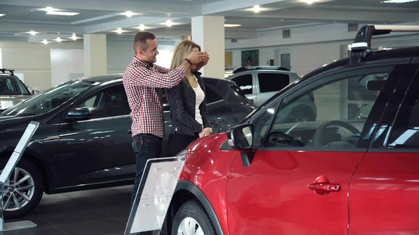 Man Surprising Woman with New Car In Show Room