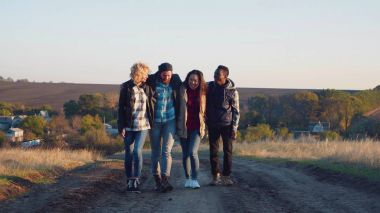 Dört çok ırklı arkadaş yürüyüş kucakladı.