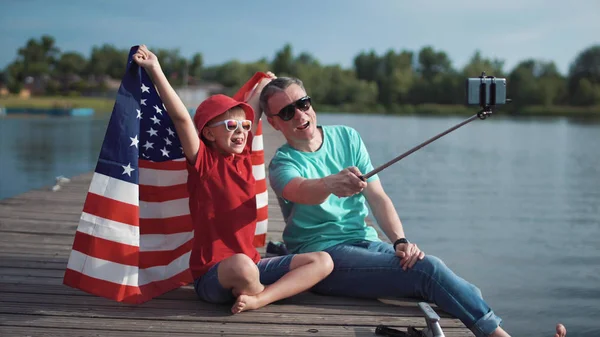 Padre e hijo posando con bandera americana — Foto de Stock