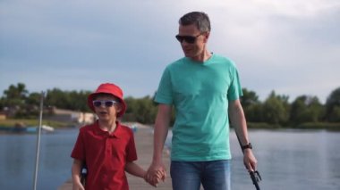 Baba ve genç oğlu akşam iskelede yürüyüş