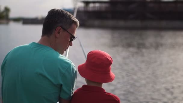 Мальчик рыбачит с отцом — стоковое видео