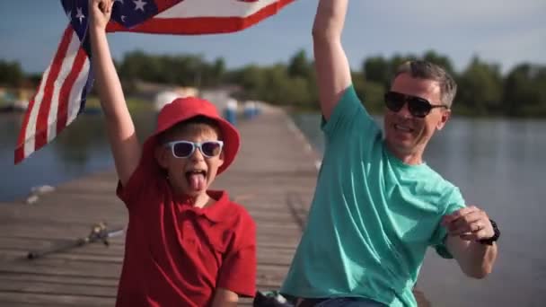 Vader en zoon poseren met Amerikaanse vlag — Stockvideo