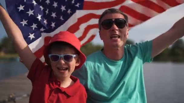 Jovem e seu pai com a bandeira americana — Vídeo de Stock