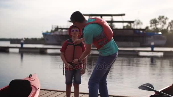 El padre entrena al hijo para nadar en un kayak — Vídeos de Stock