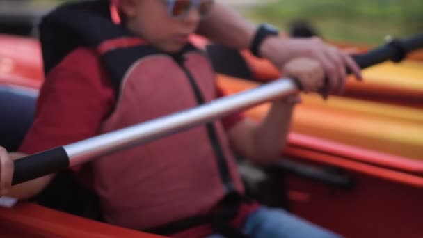 The father teaches the son how to row in a kayak — Stock Video