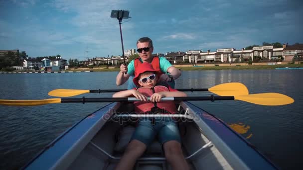 Man och son kajakpaddling — Stockvideo