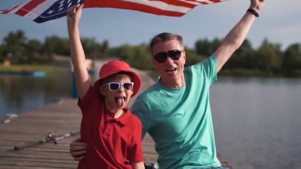 Ung pojke och hans far med den amerikanska flaggan — Stockvideo