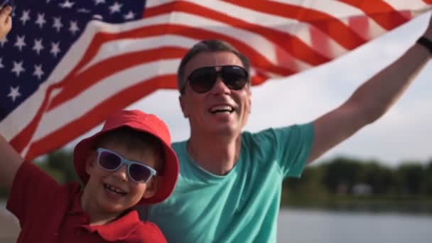 Jovem e seu pai com a bandeira americana — Vídeo de Stock