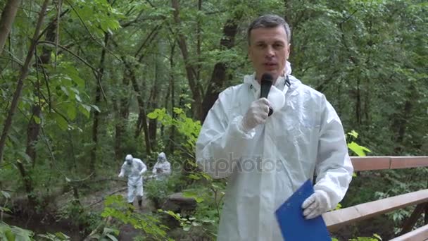 Scientist speaking microphone in woods — Stock Video