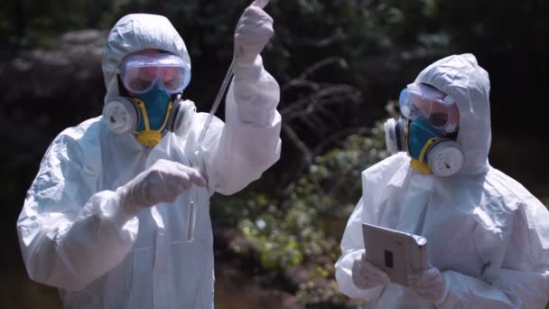 Dos hombres en trajes de riesgo biológico tomando muestras de agua — Vídeos de Stock