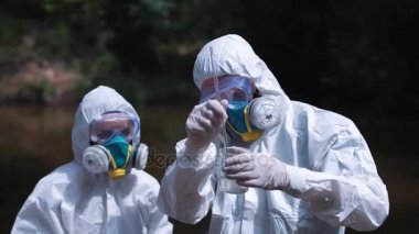 Su örnekleme biohazard elbiseli iki ekolojik işçi