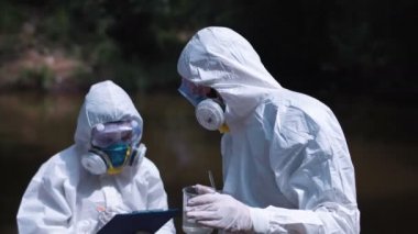 Su testi biohazard elbiseli iki ekolojik işçi