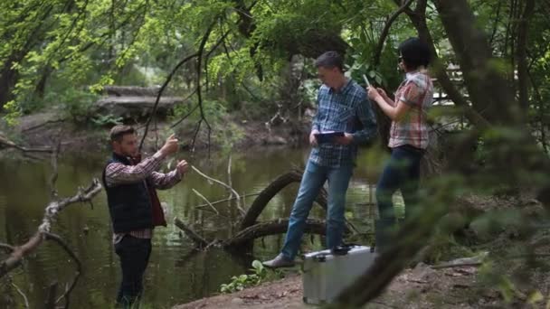 Tres científicos exploran el agua en el lago — Vídeos de Stock