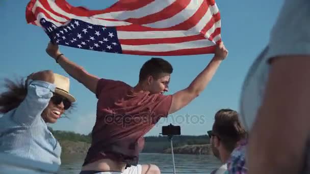 Groep jongeren verhogen Amerikaanse vlag — Stockvideo