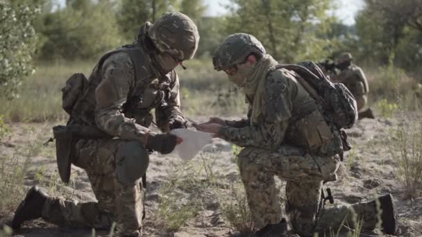 Военные, ориентирующиеся на поле боя — стоковое видео