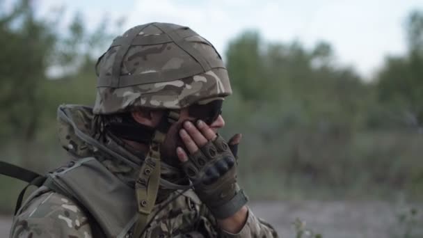 Hombre poniendo camuflaje en la cara — Vídeos de Stock