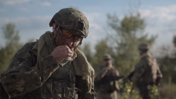 Soldat som røyker overfor andre soldater – stockvideo