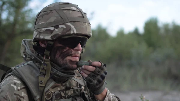 Homem colocando camuflagem na cara — Fotografia de Stock