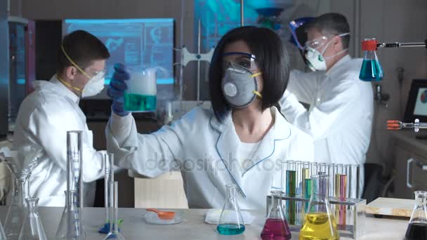 Ученые в лабораторных экспериментах с химикатами — стоковое видео