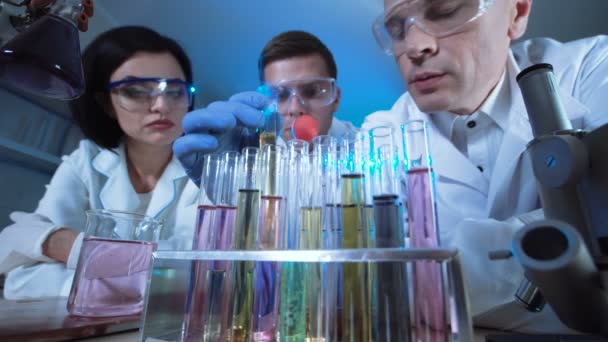 Ученые в лабораторных экспериментах с химикатами — стоковое видео
