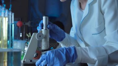 Genç kadın bilim mikroskop bakıyor