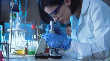 Genç kadın bilim mikroskop bakıyor