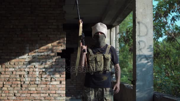 Mann posiert mit Waffe in Gebäude — Stockvideo