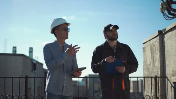 Constructor en leermeester wandelen op dak — Stockvideo