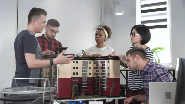 Colaboradores discutiendo por miniatura de la construcción — Foto de Stock