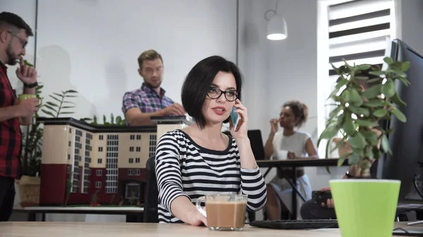 Mujer joven hablando de teléfono en la oficina — Foto de Stock