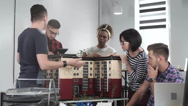 Collaboratori che discutono in miniatura dell'edificio — Video Stock