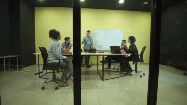 Homme écrivant sur un tableau à feuilles mobiles lors d'une réunion d'affaires 