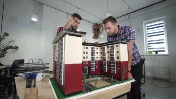 İş arkadaşları tarafından binanın minyatür tartışıyor — Stok video