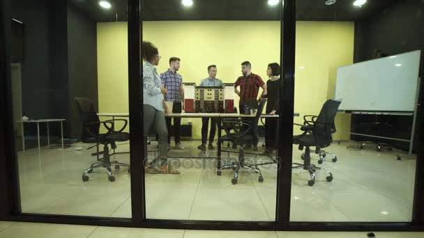 Travailleurs discutant par miniature de bâtiment 