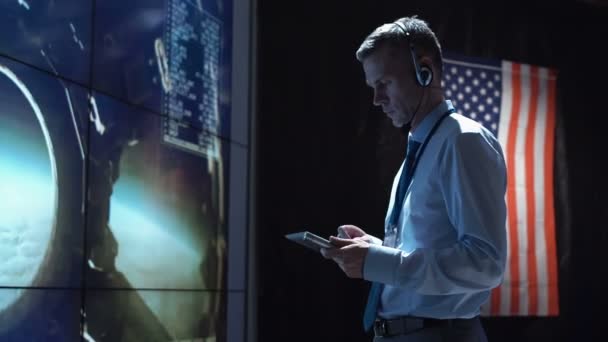 Homme avec tablette dans le centre de contrôle de mission. Éléments de cette image fournis par la NASA . — Video