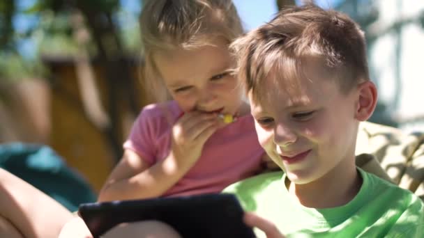 Children enjoying tablet in backyard — Stock Video