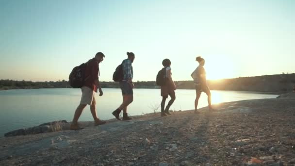 Mochileros caminando por la costa a la luz del sol — Vídeos de Stock