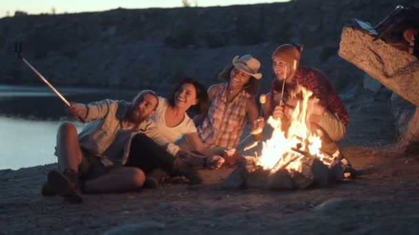 Fröhliche Freunde entspannen am Lagerfeuer — Stockvideo