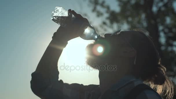 Mann trinkt Wasser im Sonnenlicht — Stockvideo