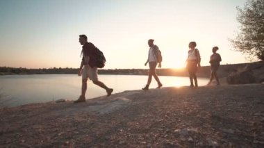 Güneş ışığı altında kıyısında yürüyüş backpackers