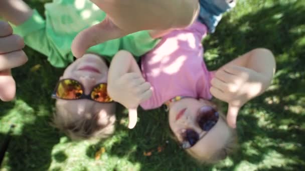 Дети лежат на земле и жестикулируют — стоковое видео