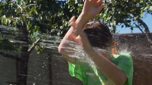 Kid being poured with water in garden — Stock Video