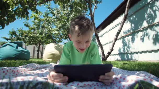 Niño comunicándose con la tableta en el jardín — Vídeos de Stock