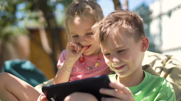 Children enjoying tablet in backyard — Stock Video