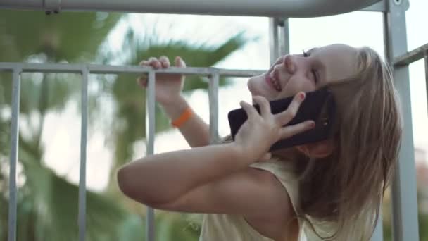 Усміхнена дівчинка розмовляє телефоном — стокове відео
