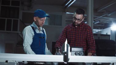 Tasarımcı ve çizimler tartışırken marangoz