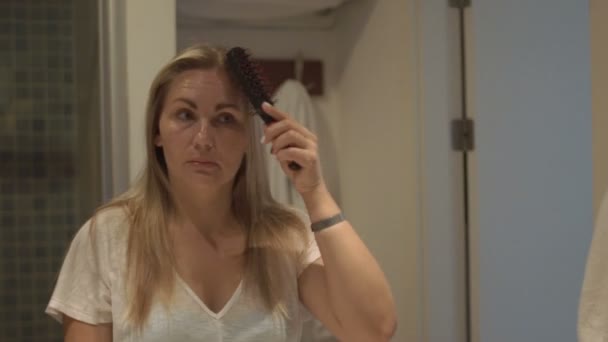 En kvinna kammar sitt hår. — Stockvideo