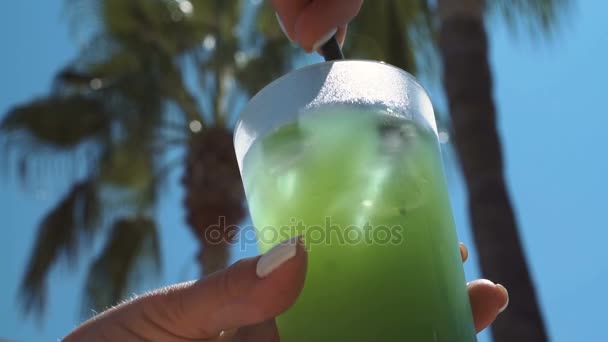 Femme remuant boisson avec de la paille 